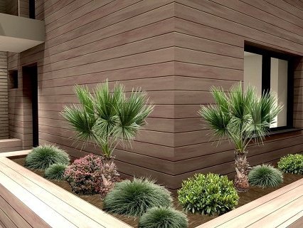 Ansicht einer Fassade in Holzoptik. Pflanzen stehen im Vordergrund.